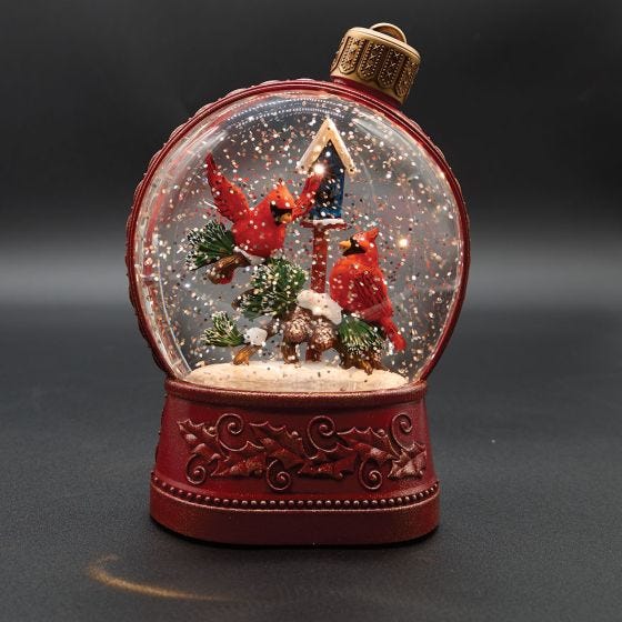 cardinal snow globe on black background 